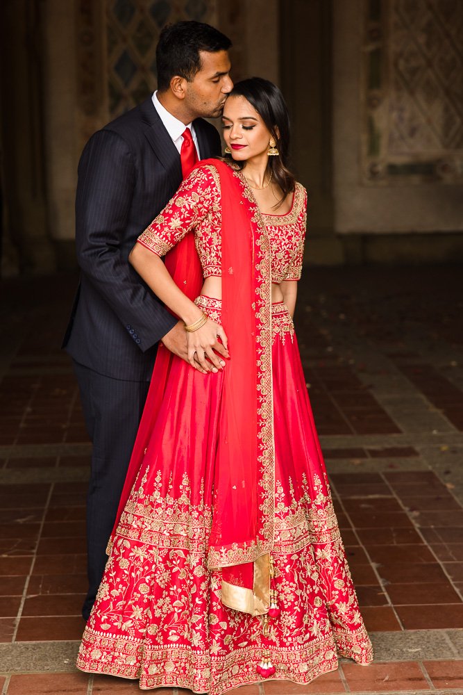 woman in red sari and man in suit at Bethesda terrace in Central Park