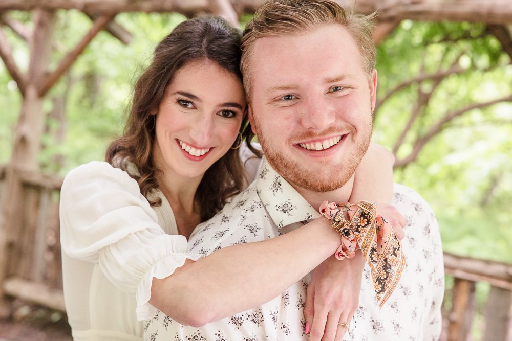 woman hugging man from behind under arbor