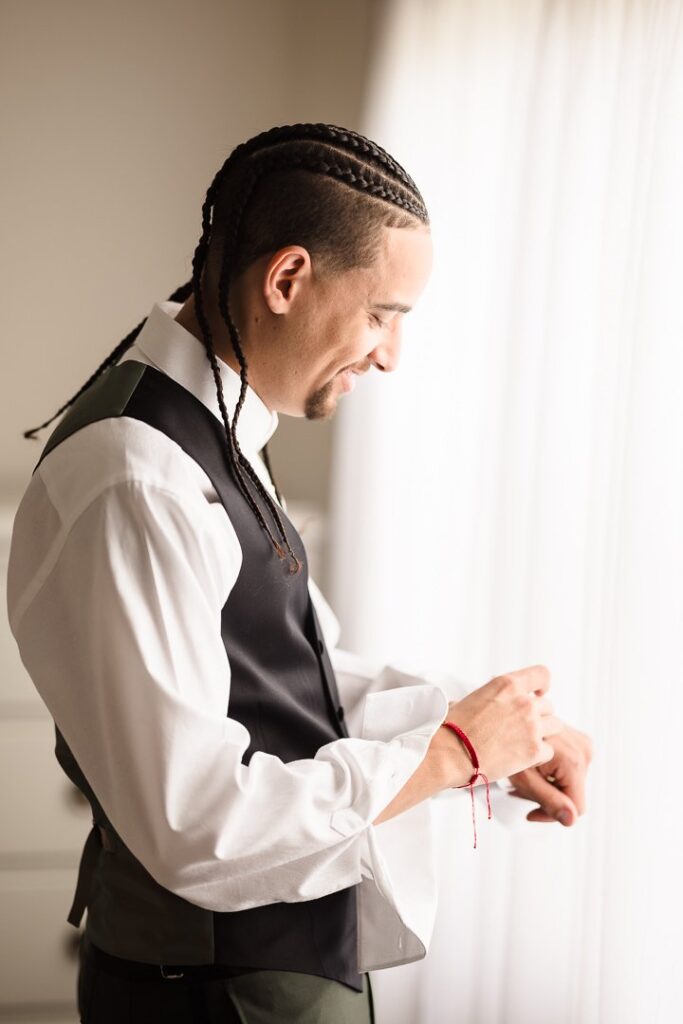 groom putting on cufflinks