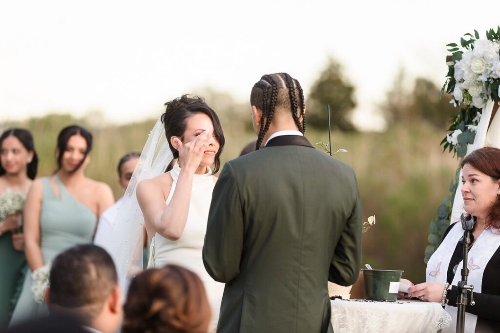 bride wiping away tear at Mansion at West Sayville