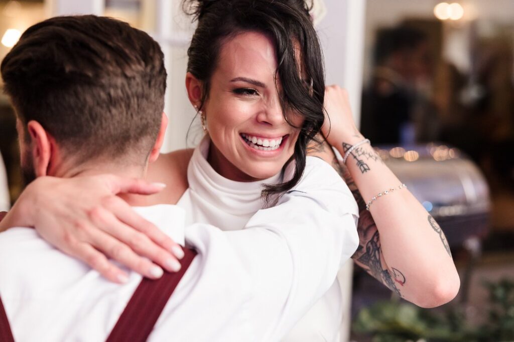 Bride hugging guest on dance floor at Mansion at West Sayville