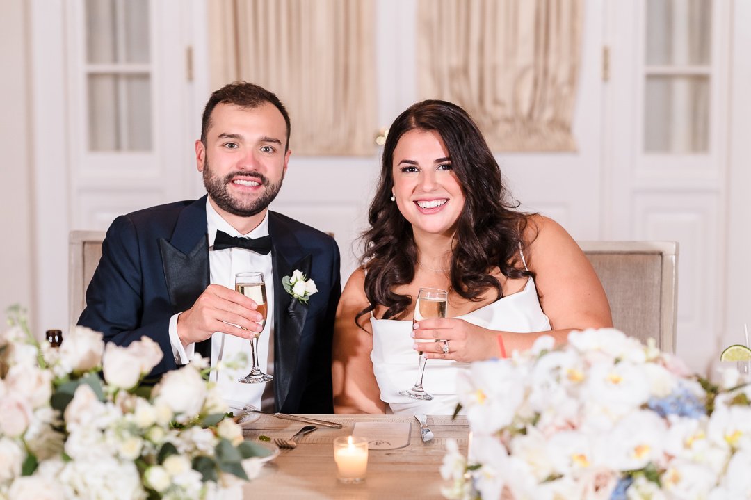 bride and groom at sweetheart table with champagne at Heritage Club