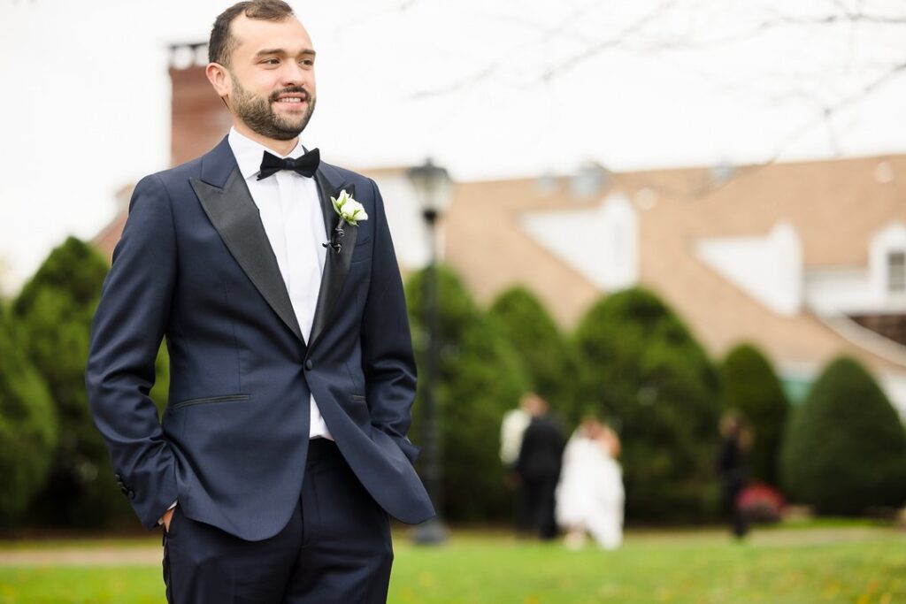 groom looking away before first look while bride walks toward him