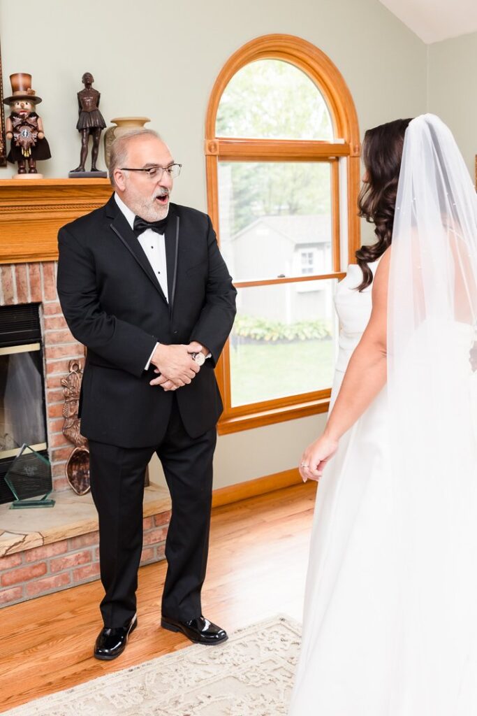 father of bride having first look with bride in family den