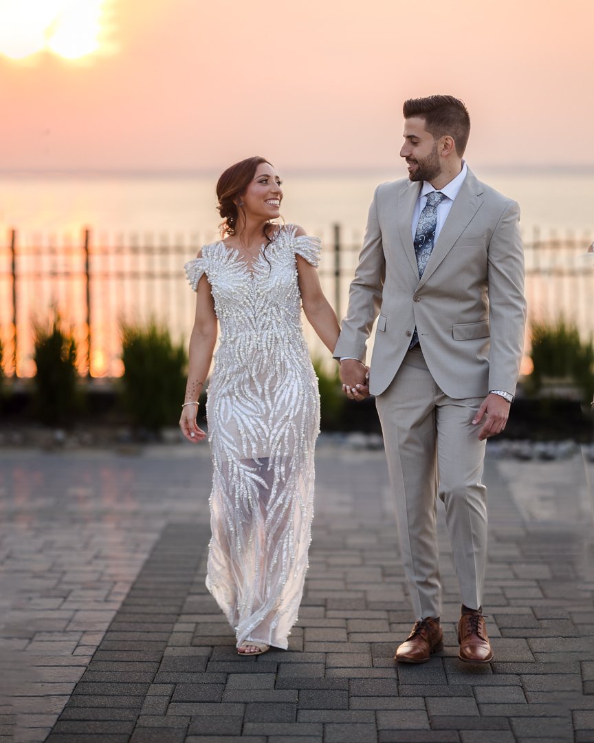 bride and groom holding hands and walking at Soundview caterers