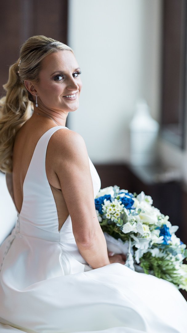 bride sitting with bouquet looking at camera at Gatsby On The Ocean