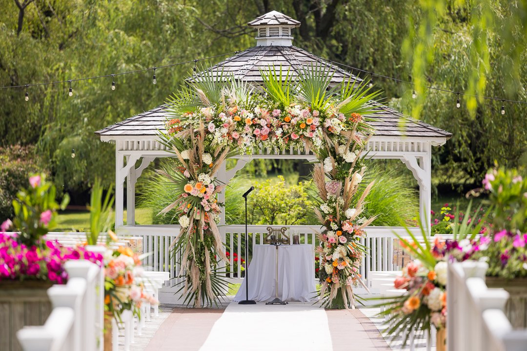 elaborate floral archway on gazebo for wedding ceremony