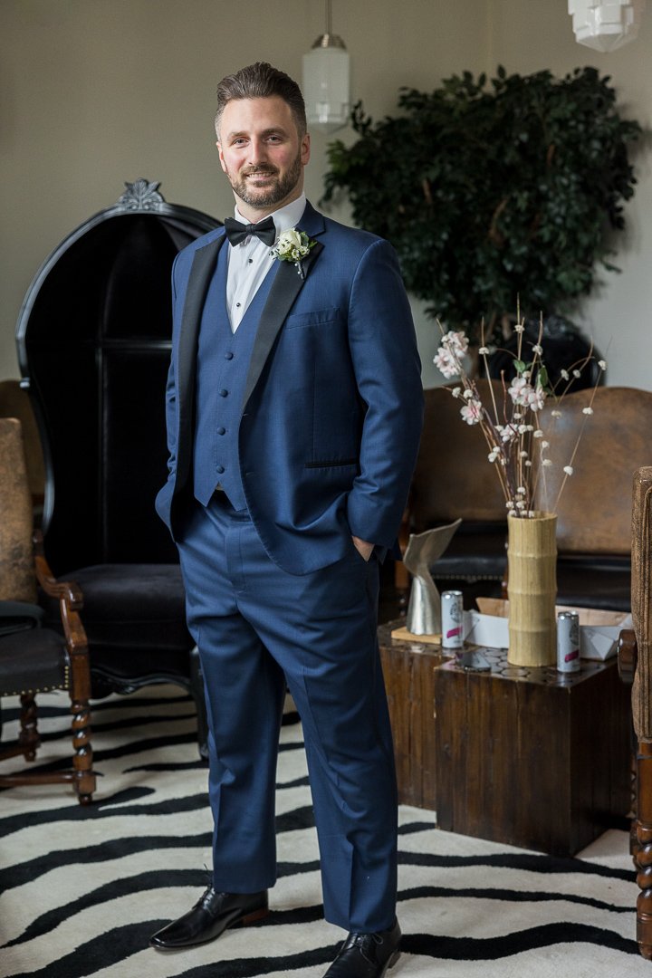 groom standing fully dressed in suite at Gatsby On The Ocean