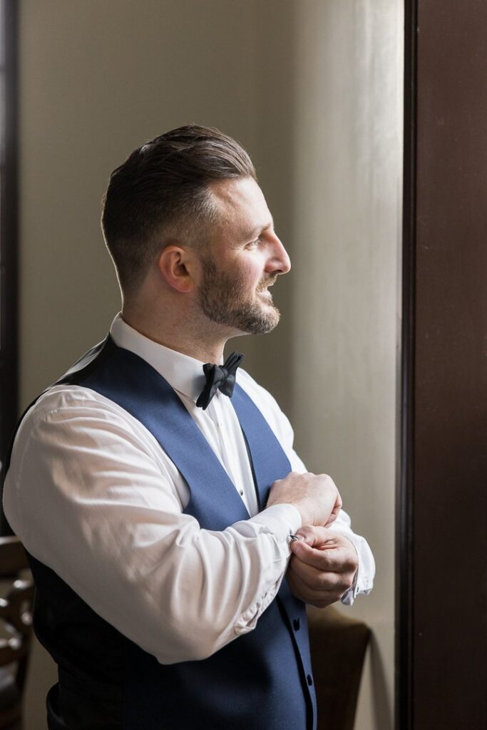 groom attaching cufflinks at Gatsby On The Ocean