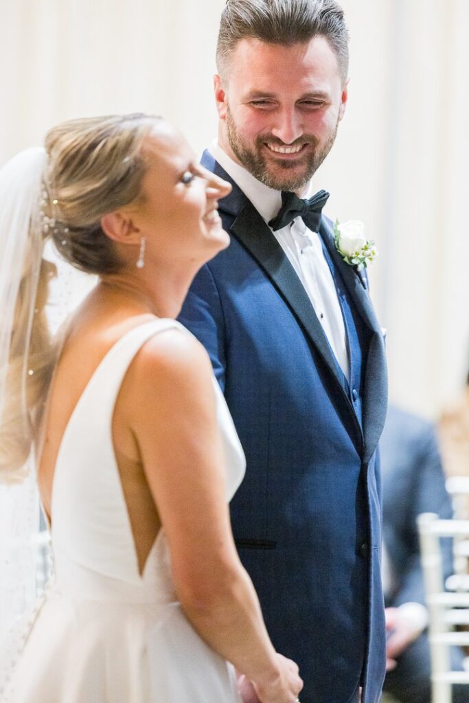 groom looking at bride during indoor ceremony at Gatsby On The Ocean