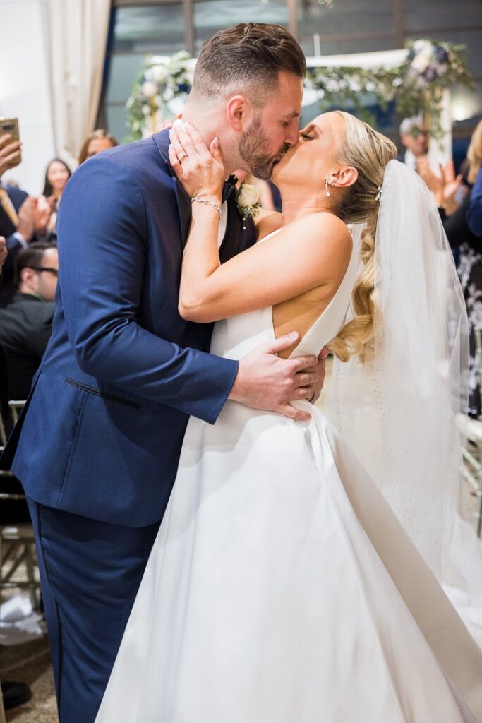 bride groom kissing after indoor ceremony at Gatsby On The Ocean