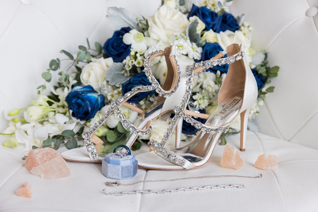 rings shoes and flowers with blue tones on a white couch at Gatsby on the Ocean