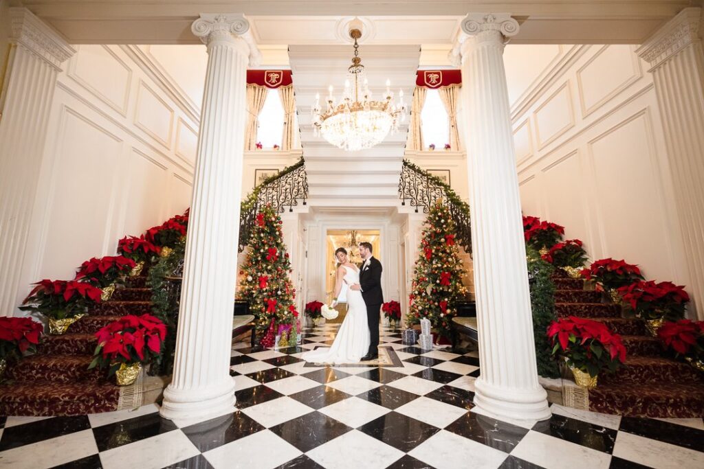 Bride and Groom pose in front of a beautiful grand staircase.