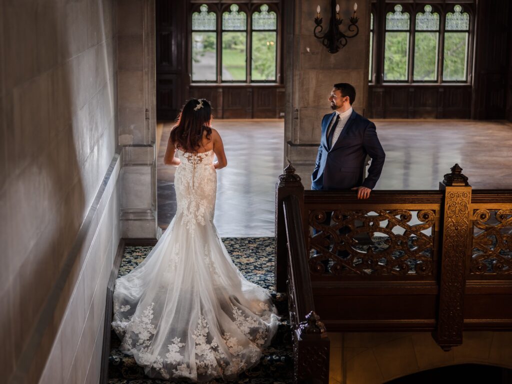 Couple stands on the grand staircase inside Hempstead House.