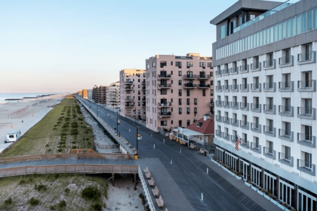 Exterior view of the hotel and boardwalk overlooking the water.