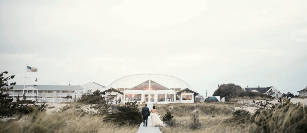 Couple walks to their wedding reception after a ceremony on the beach.