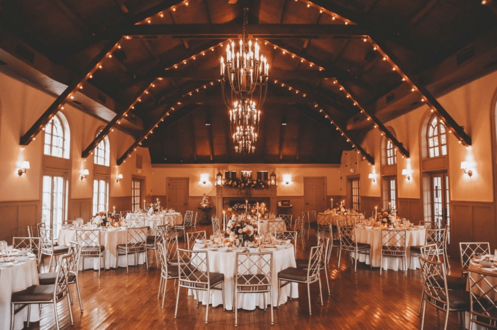 Warm ambiance exudes from the ballroom set up for a wedding reception.