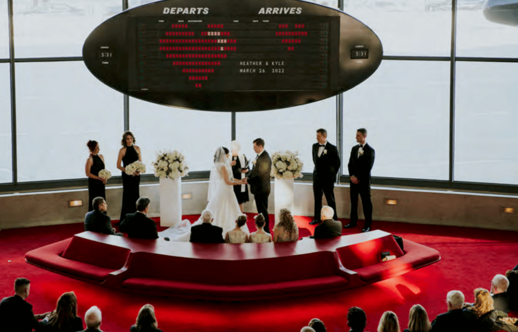 Couple exchanging vows at the retro TWA Hotel.