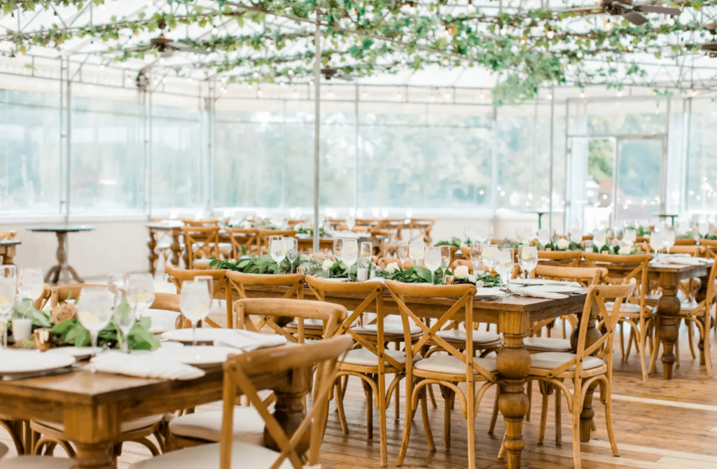 Wedding reception setting inside a beautiful greenhouse.