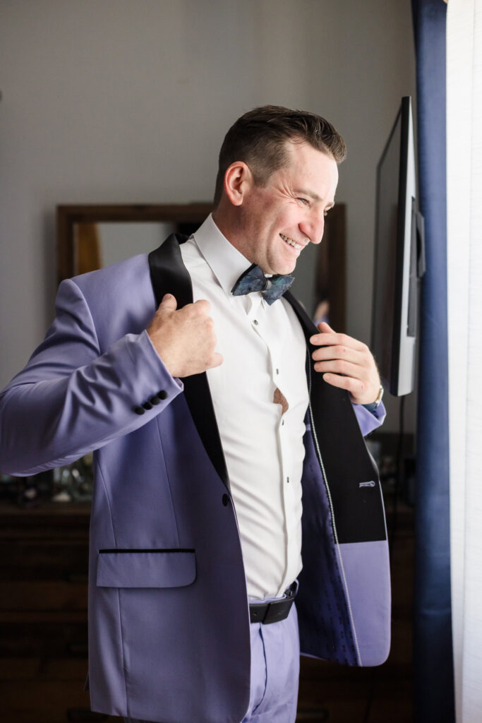 Groom putting on his jacket.