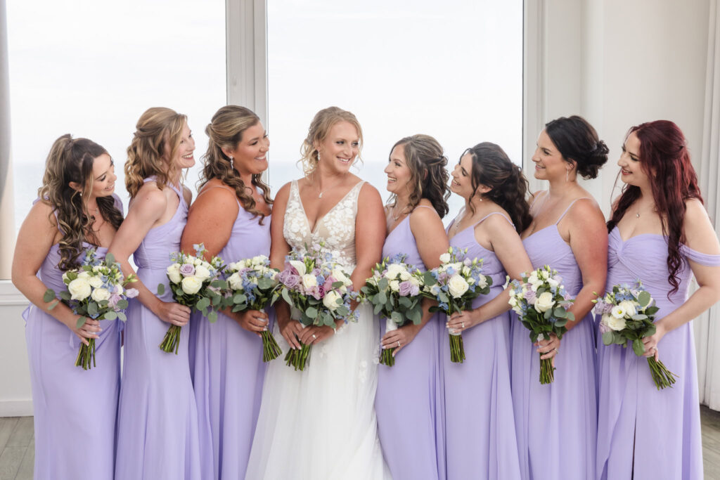 Bride and bridesmaids laughing with each other in the rooftop bar of the Allegria Hotel