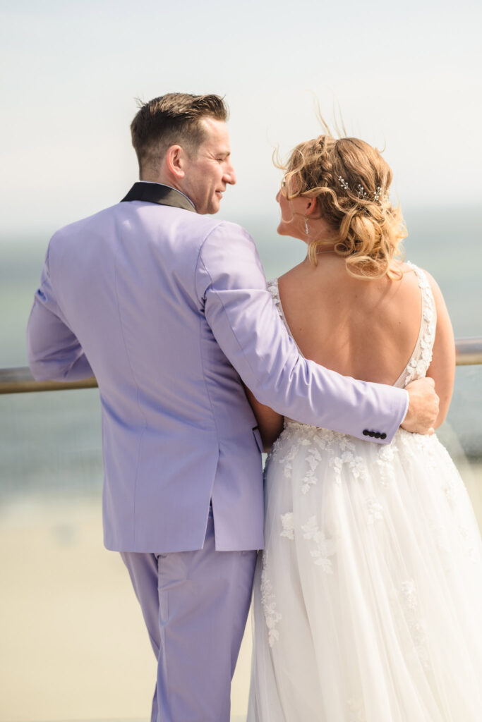 Bride and groom looking at each other on the rooftop of the Allegria Hotel with the ocean in the background.