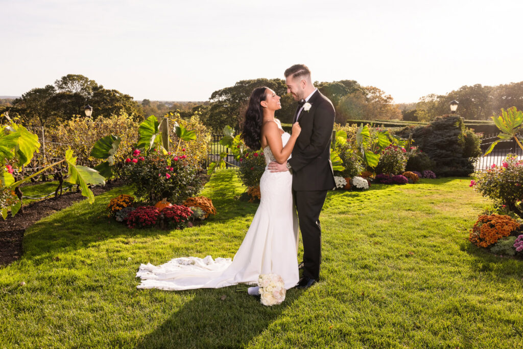 Bride and groom embracing in the gardens at Giorgio’s Baiting Hollow during warm golden-hour light.