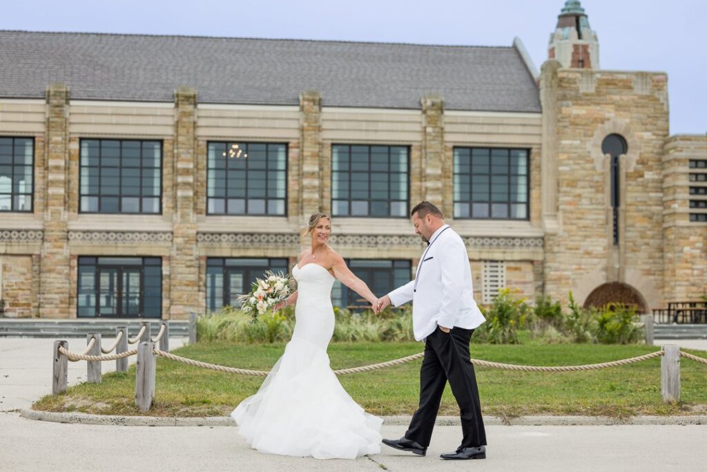 bride and groom walking in front of Gatsby on the Oceans art deco facade.