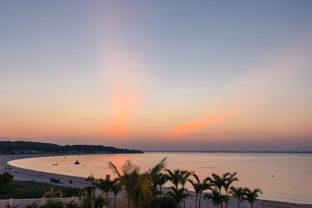 Sunset over the water and shoreline at Crescent Beach Club on Long Island.