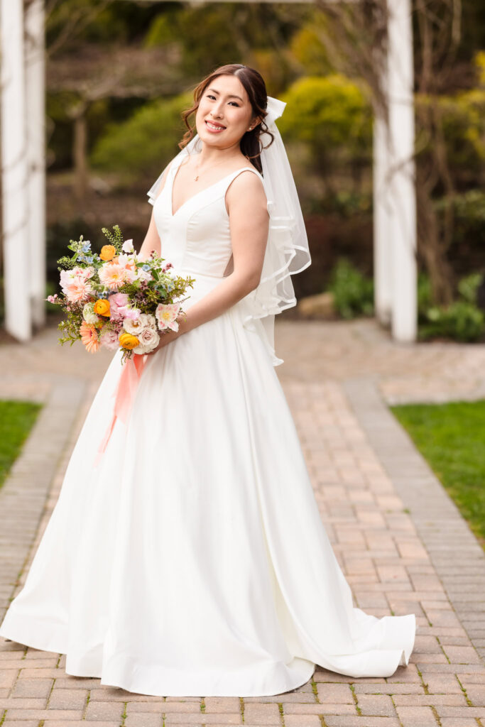 Full length image of bride looking at the camera while holding bouquet at Fox Hollow