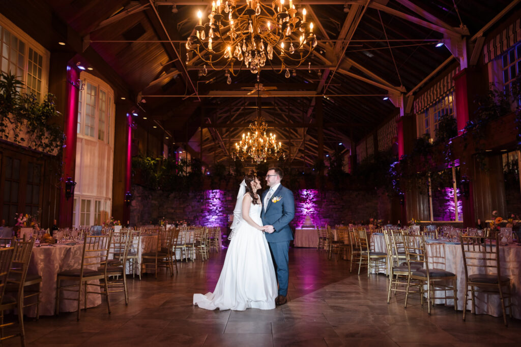 Bride and groom standing in the winter garden room reception area.