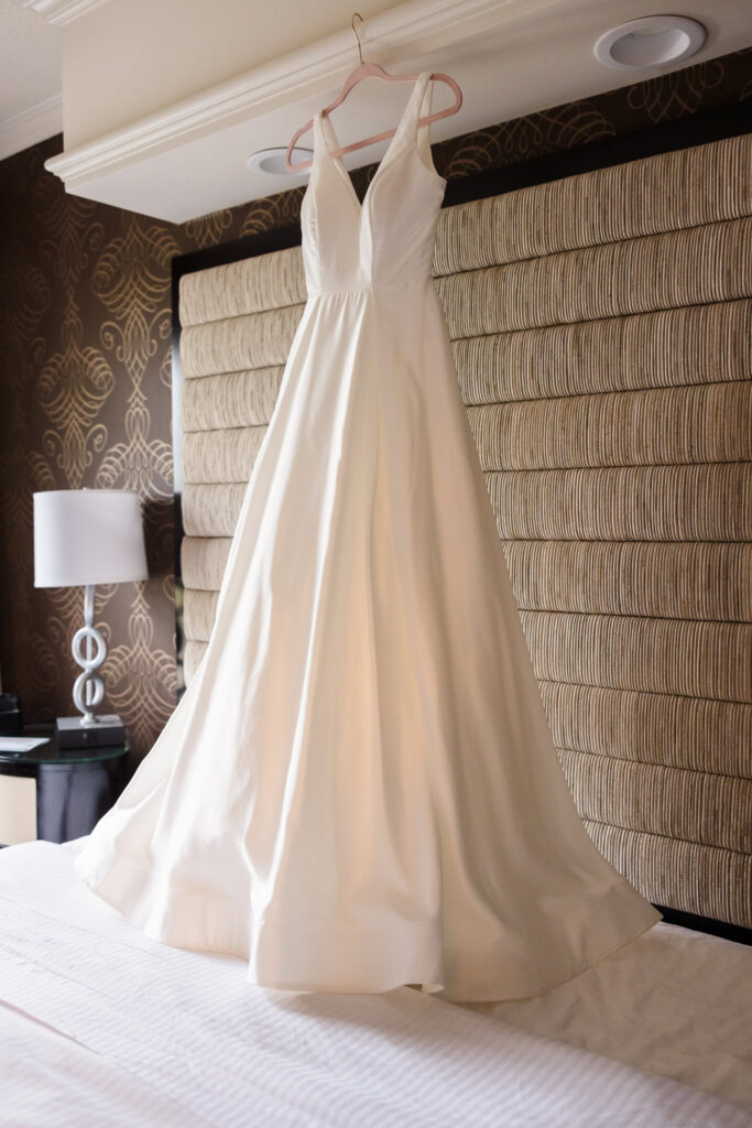 Wedding dress hanging above bed at The Inn at Fox Hollow.