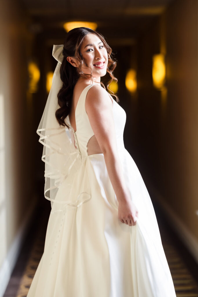 Bride in hallway of In at Fox Hollow turning to look at camera.