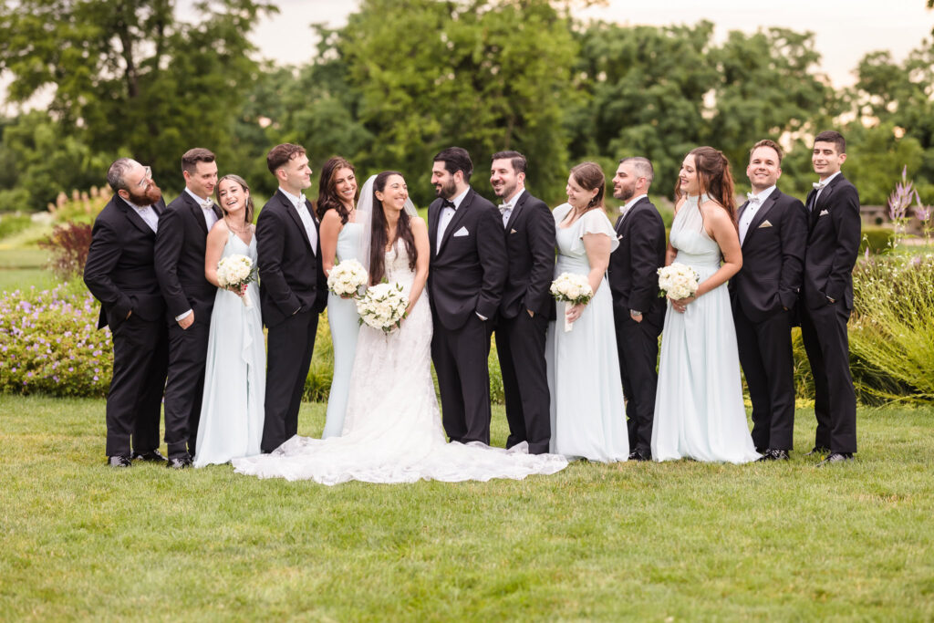 Bridal party laughing with each other at Hempstead House garden at Sands Point