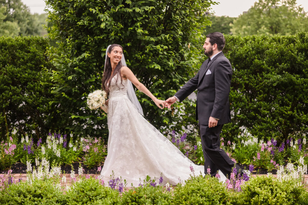 Bride leading groom through gardens at Larkfield