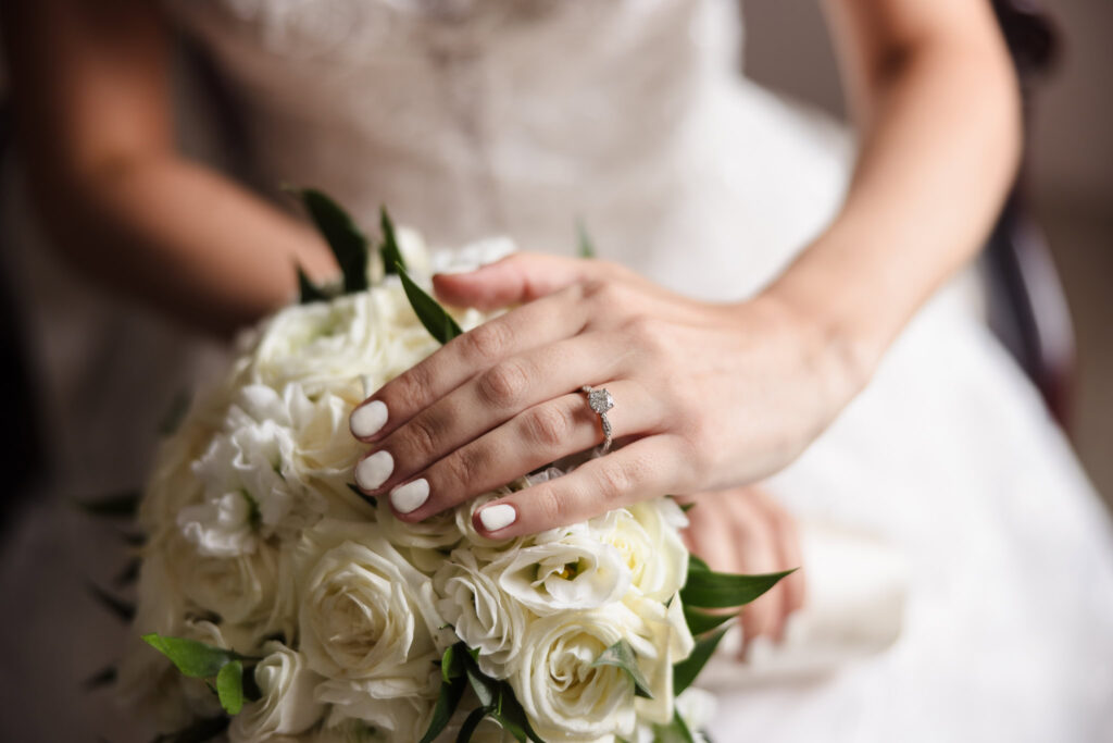 close up of bride's hands on top of bouquet