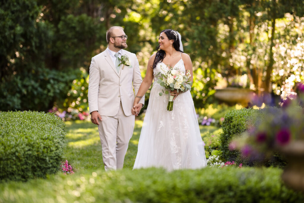 Bride and groom walking through gardens at Majestic Gardens.