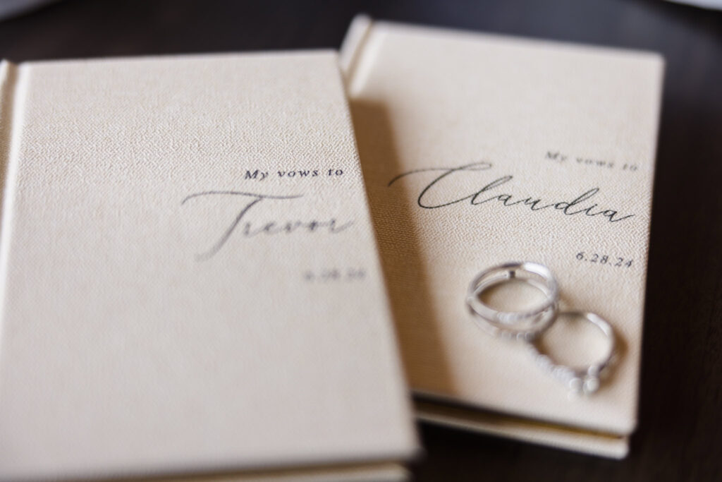 Wedding rings on top of custom vow books.