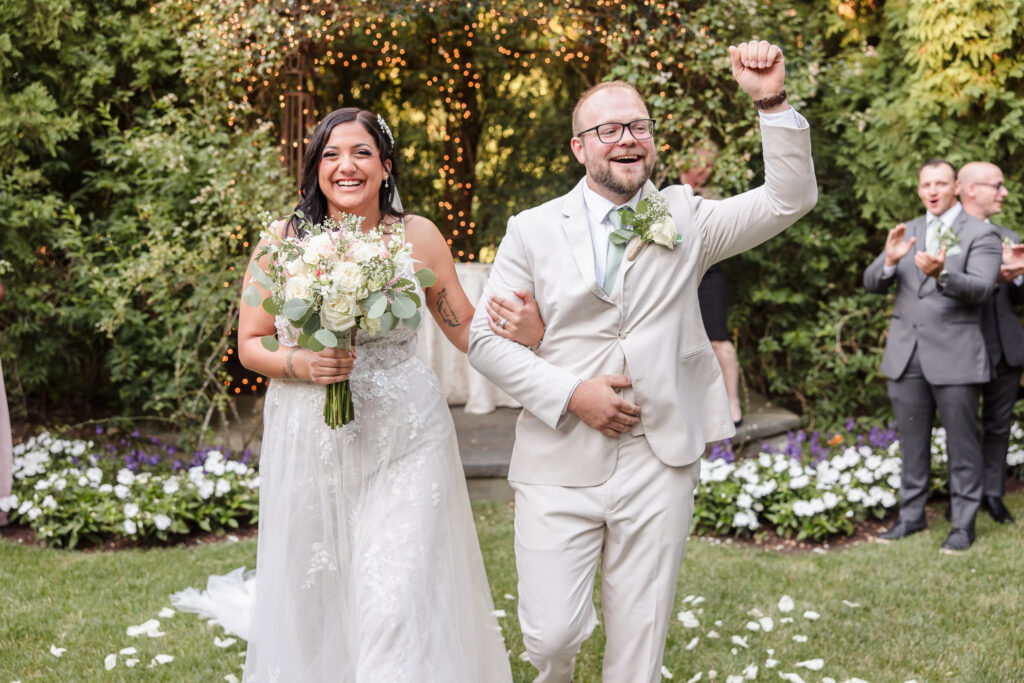 Couple walking down aisle celebrating after their wedding.