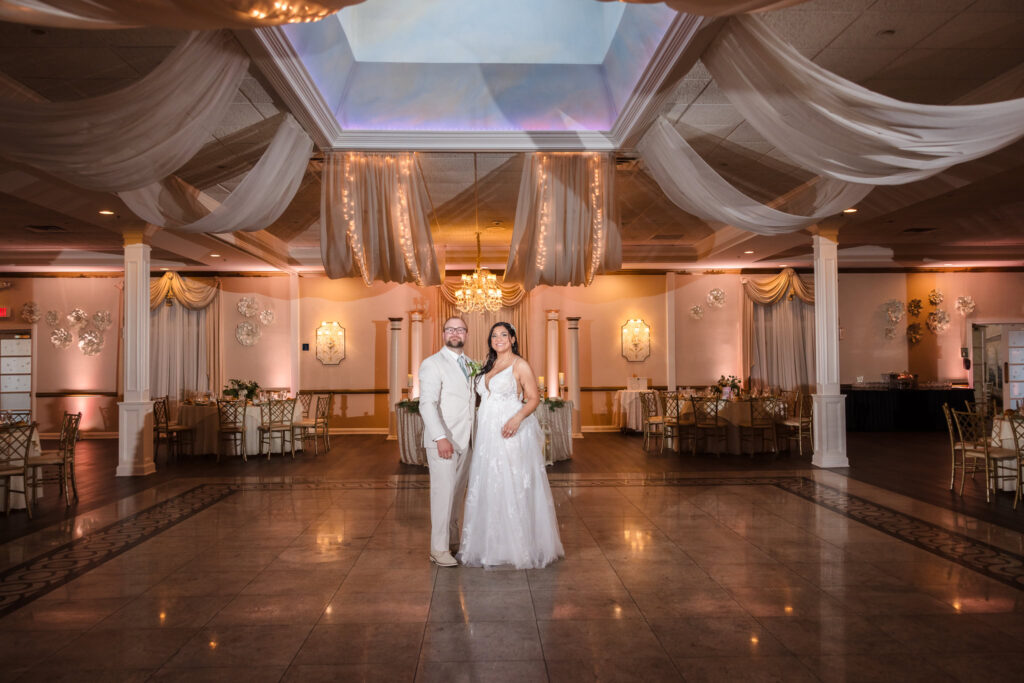 Bride and groom looking at the camera while alone in the ballroom of Majestic Gardens