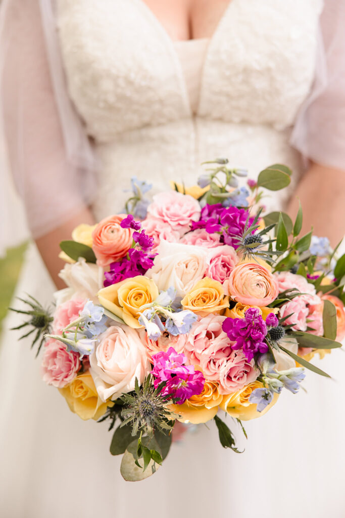 Bride holding colorful bouquet.