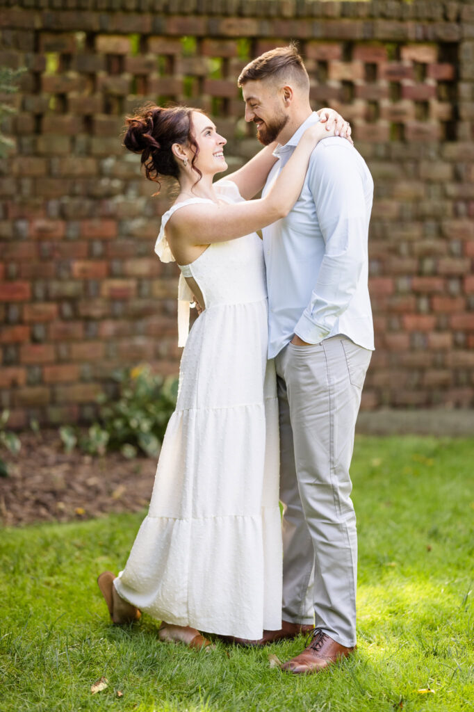 Woman and man embracing at Planting Fields Arboretum.