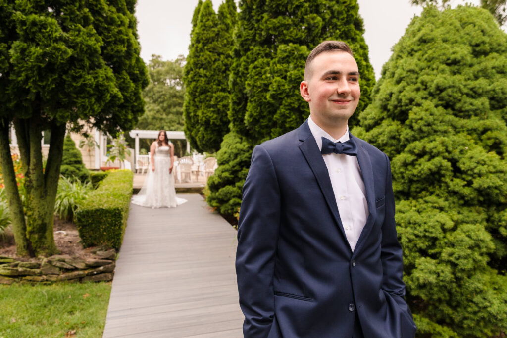 Groom at Rock Hill Country Club with bride walking toward him.