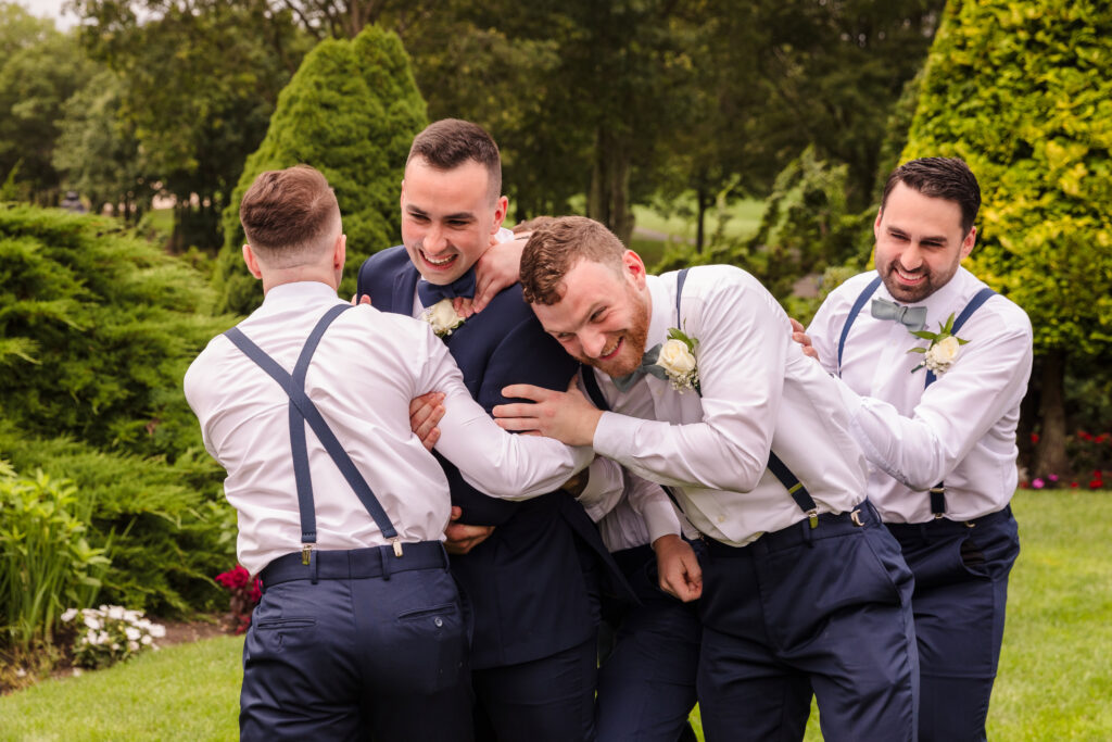 Groom being tackled by groomsmen at Rock Hill Country Club.