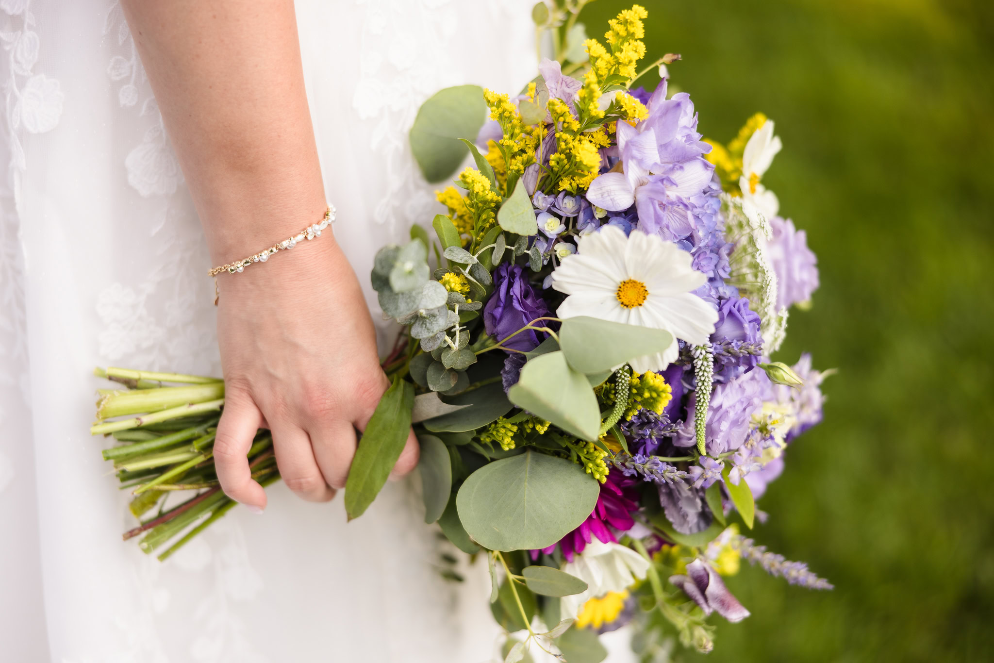 Bride hold bouquet by her side.