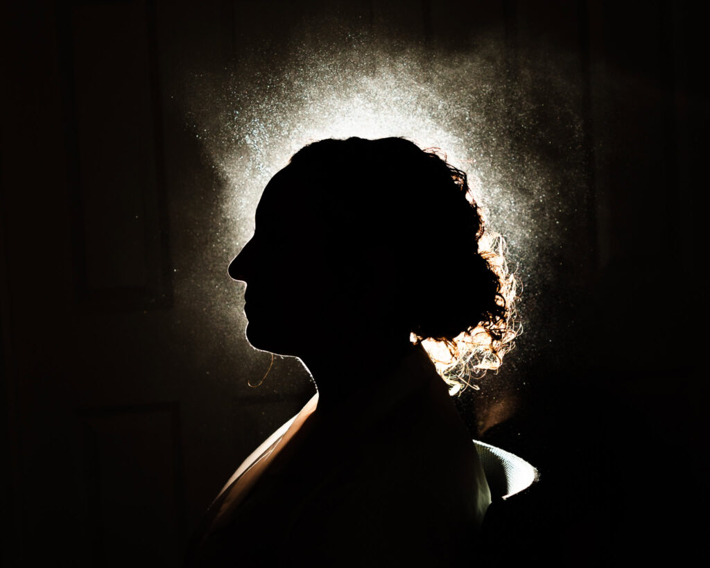 Hairspray shot of bride in silhouette.