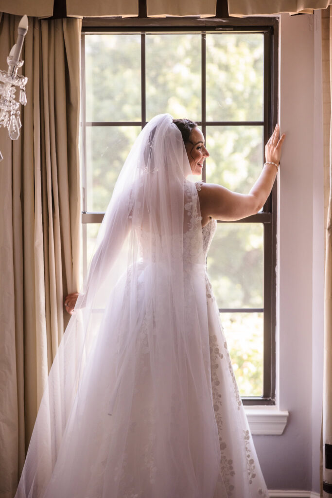 Bride in window looking toward the right at The Inn at Fox Hollow.