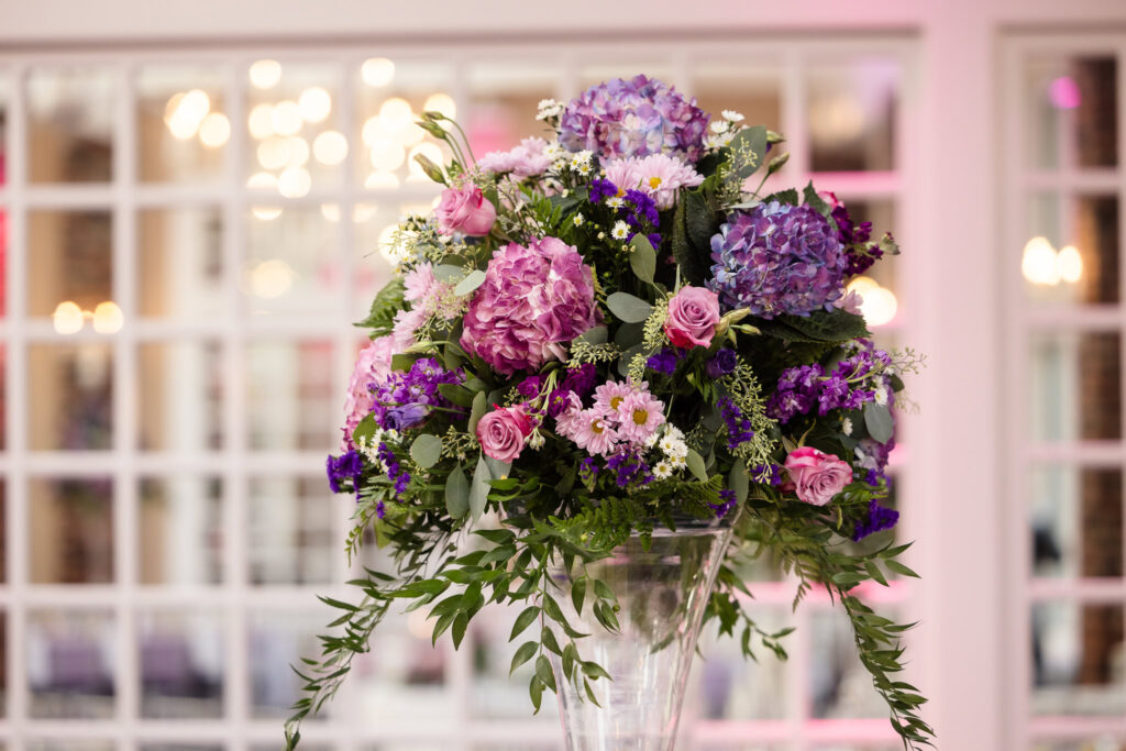 Floral centerpiece with purple flowers at The Coral House.