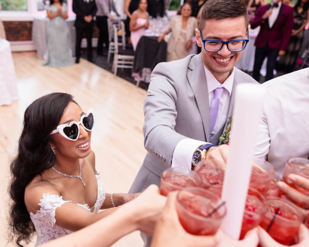 Bride and groom toasting with their friends on the dance floor at The Coral House.