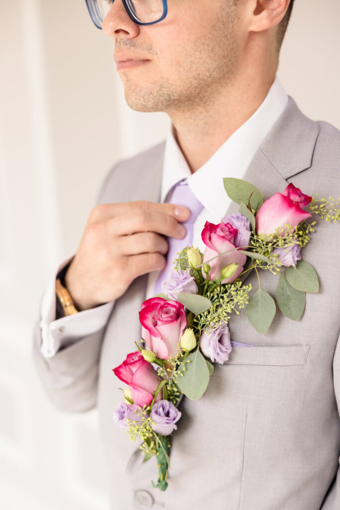 Close up of the groom fixing his tie at The Coral House.